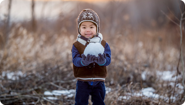 Young boy holding a snowball