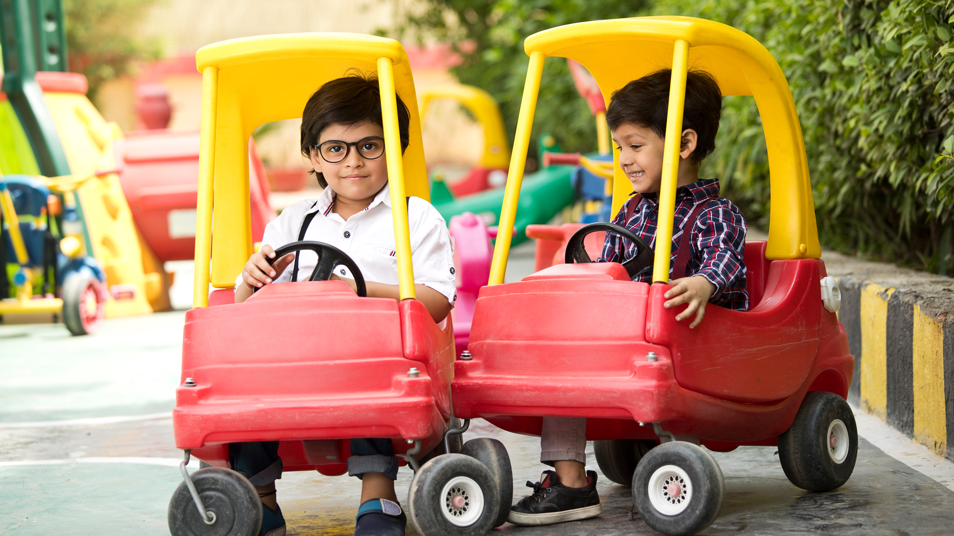 Children playing with cars outside, developing gross motor skills