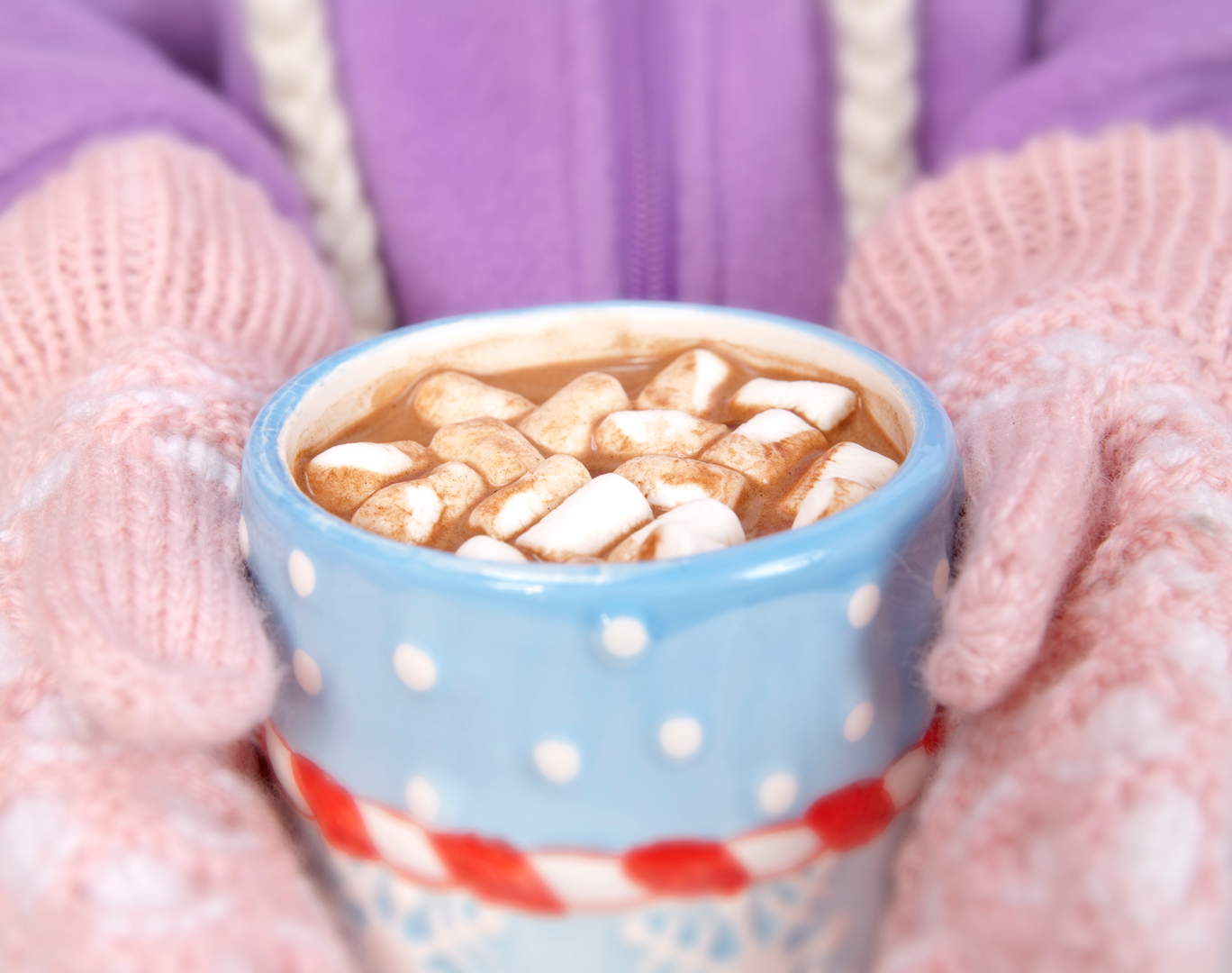 Child holding hot chocolate during Christmastime