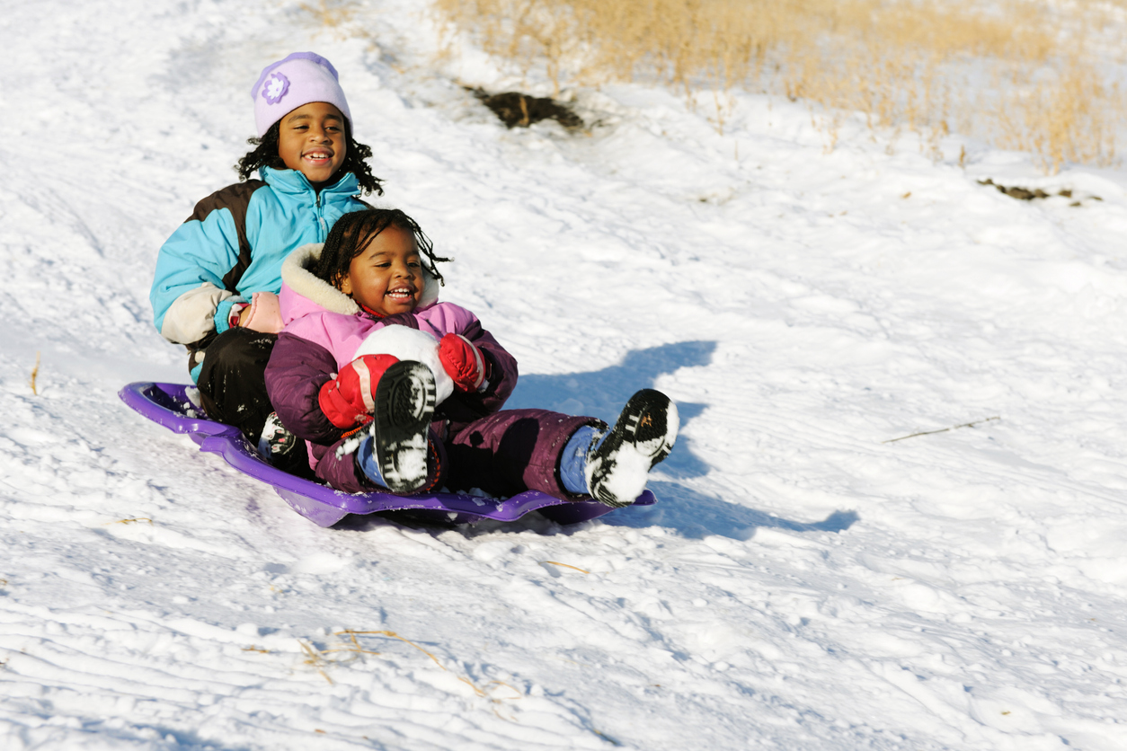 Kids sledding outside in the snow